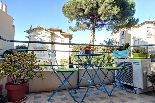 戛纳HENRI CAMILLE REAL ESTATE - CARNOT - Nice studio 8min Palais的阳台配有两把椅子和一棵树