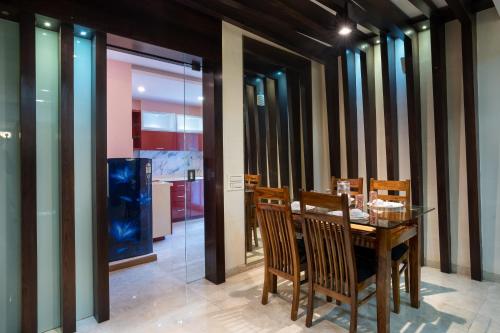 孟买Home2 Suites and Service Apartments, Mumbai Airport的一间带木桌和椅子的用餐室
