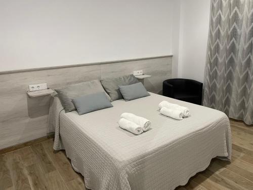 科尼尔-德拉弗龙特拉alojamiento saturno1的一张白色的床,上面有两条毛巾