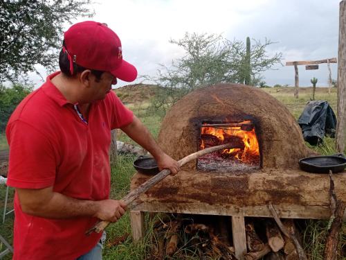 比利亚维哈Mirador Valle de la Tatacoa的一个人在砖炉里做饭