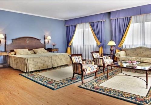 普拉森西亚Hospedium Hotel Doña Mafalda de Castilla的卧室配有一张床和一张桌子及椅子