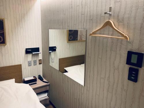 武藏野Takahashi Building 3rd and 4th floors - Vacation STAY 24477v的墙上的镜子,在一张床上