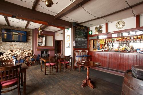 普里茅斯轮渡旅馆的餐厅设有酒吧,配有木桌和椅子