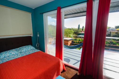 新戈尔戈纳Aparthotel Pelican's Surf Club的一间卧室设有一张床和一个大窗户
