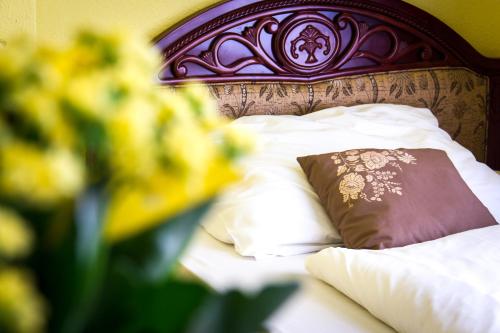 布达佩斯City Hotel UNIO superior的一张带棕色枕头和白色枕头的床