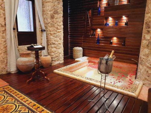 巴利亚多利德La Casa del Encomendero的带浴缸的客房和一张桌子,铺有木地板