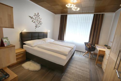 Sankt Andrä bei FrauenkirchenHaus Josef的一间卧室配有一张床、一张书桌和一个窗户。