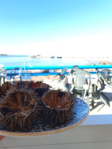 巴勒莫Teatro del Sole Mare Sferracavallo的海滩附近的一张桌子上有一个蓝色的盘子,上面有两只榴莲