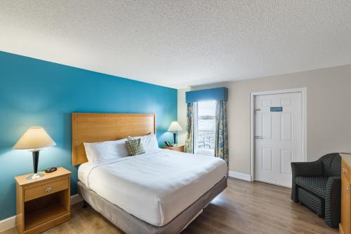 弗吉尼亚海滩Ocean Key Resort by VSA Resorts的配有一张床和一把椅子的酒店客房