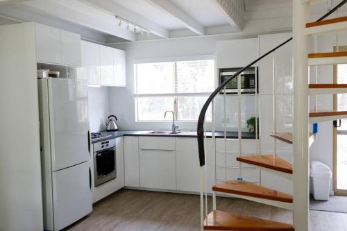 邓斯伯勒Dunsborough Beach Shack的白色的厨房配有水槽和冰箱