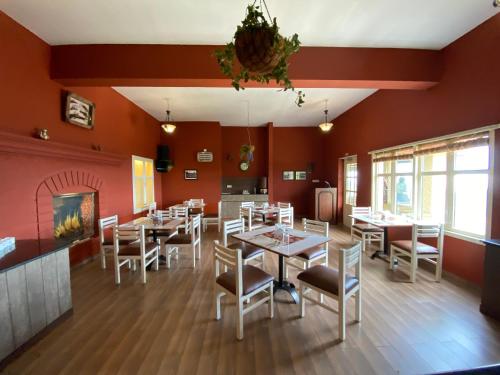 乌提Mountain Retreat - A Hill Country Resort的一间拥有红色墙壁和白色桌椅的用餐室