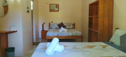 马拉帕斯加JPH Resort的酒店客房,配有两张带白色床单的床