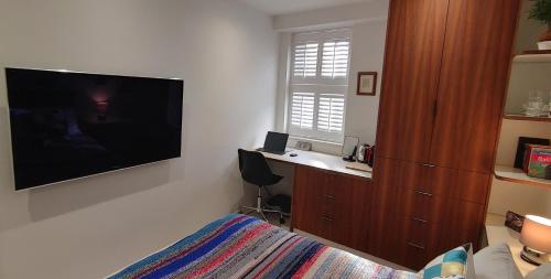 伦敦Comfortable Room With Ensuite的一间卧室配有大屏幕平面电视和一张床