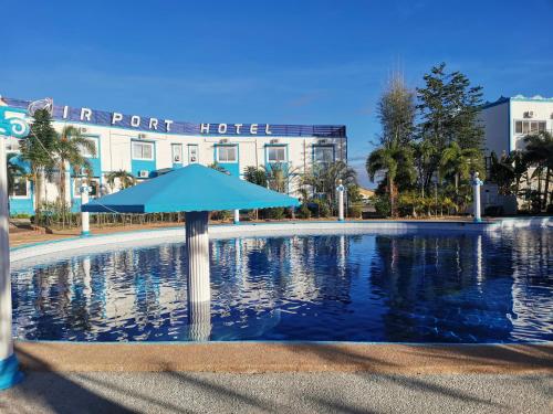 安吉利斯Airport Hotel Clark的酒店前方的大型游泳池配有遮阳伞
