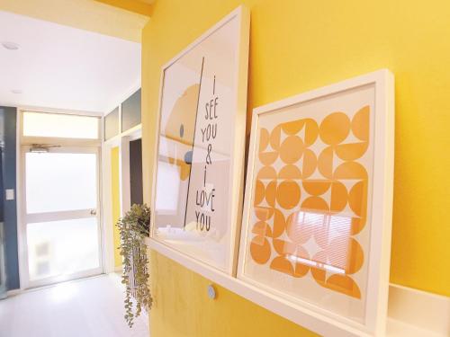 广岛OUCHI HOTEL Nagarekawa with Dogs的黄色的房间,有两张画架