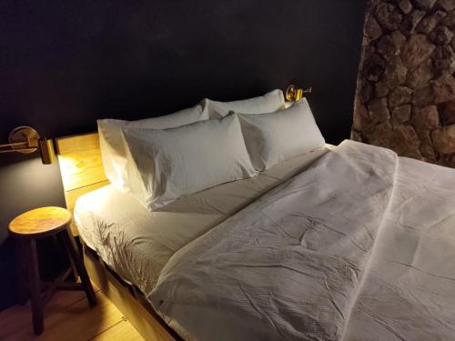九份山茶雅舍2022的一张带白色床单和枕头的床