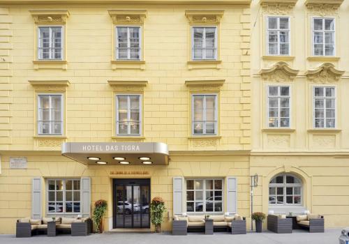 维也纳Boutique Hotel Das Tigra的黄色的建筑,上面有读酒店狮子的标志