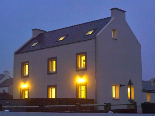 朗波普卢阿尔泽l'Aod, maison d'hôtes insulaire的白色的房子,晚上有窗户