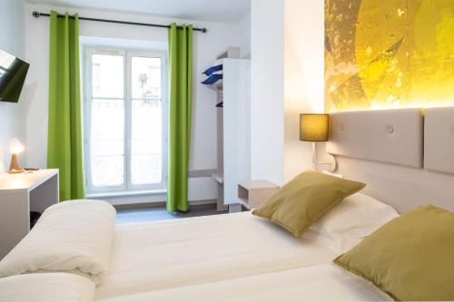 斯特拉斯堡维多利亚酒店的一间卧室设有床铺和一个带绿色窗帘的窗户。