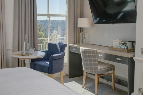 巴斯Lansdown Grove Hotel的酒店客房,配有一张床、一张桌子和椅子