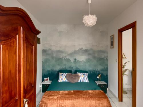 罗莫朗坦les Thiausères的卧室配有一张床,墙上挂有绘画作品