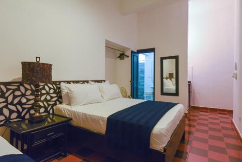 圣多明各PH 19 Guesthouse Hotel in Gazcue的一间卧室配有一张大床和镜子
