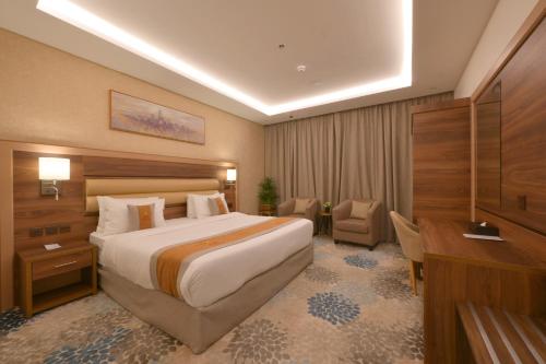 麦地那Azard Hotel的酒店客房设有一张大床和一张书桌。
