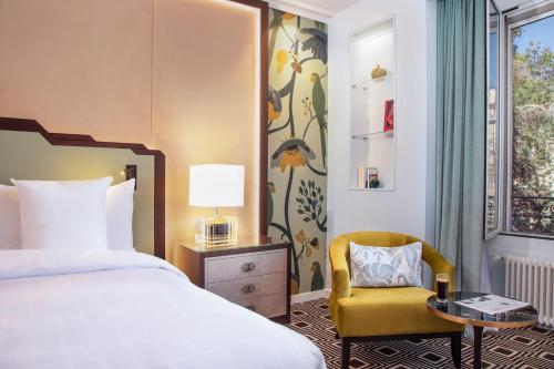 日内瓦布里斯托尔酒店的配有一张床和一把椅子的酒店客房