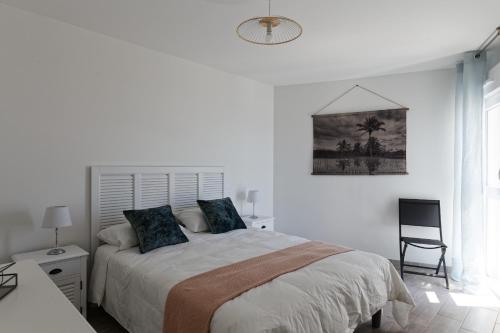 拉盖里尼耶尔Superbe appartement neuf face plage sur l ile de Noirmoutier的白色卧室配有床和椅子