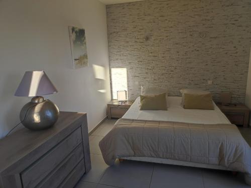 弗雷瑞斯VILLAS-Piscine les MIMOSAS的一间卧室设有一张床和砖墙