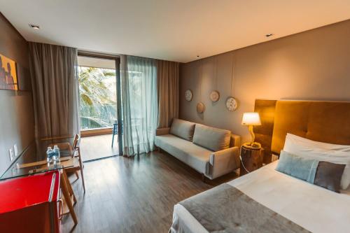 卡姆布库Carmel Cumbuco Resort的酒店客房,配有床和沙发