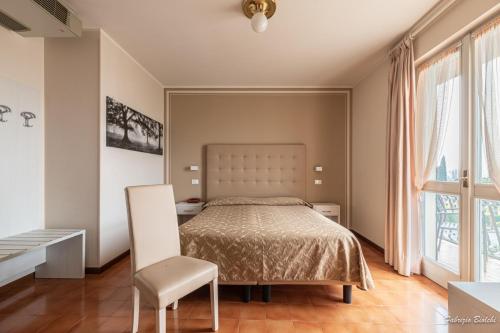西尔米奥奈巴格纳旅馆的一间卧室配有一张床和一把椅子
