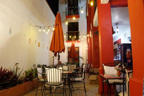 瓦哈卡市唐马里奥旅馆的一间带桌椅和遮阳伞的用餐室
