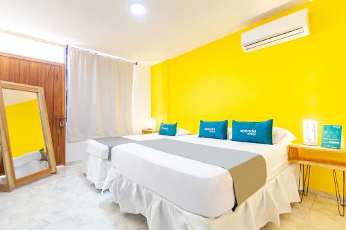 巴耶杜帕尔Ayenda Casa Paulina的一间卧室设有一张黄色墙壁的大床