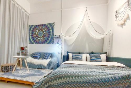 南宁野有蔓草民宿空间的一间卧室配有一张带蓝色和白色枕头的床