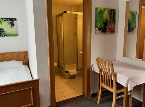 KlausHotel-Pension Sternen的小房间设有桌子和淋浴