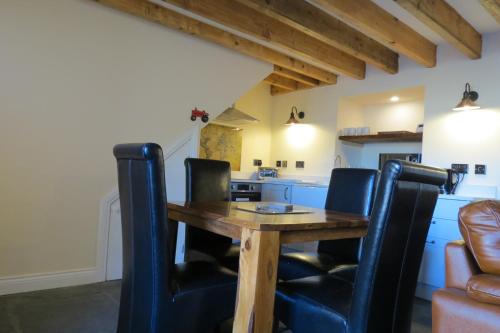 毕晓普奥克兰Farthing Cottage的厨房配有木桌和黑色椅子