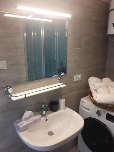 阿尔玛·迪·塔吉亚Casa Tulina Appartamenti的一间带水槽和镜子的浴室以及一台洗衣机