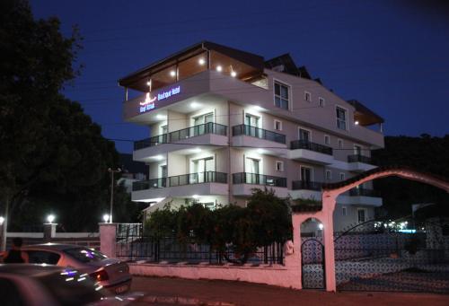 艾登Keyf Konak Boutique Hotel的白色的建筑,晚上有标志