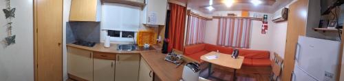 弗龙泰拉Lodge Rabasquinha的一间小厨房,在火车上配有红色沙发