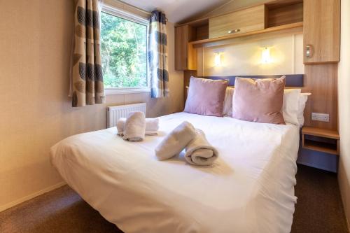 霍尔特Beechcroft - Norfolk Cottage Agency的卧室配有白色床和毛巾