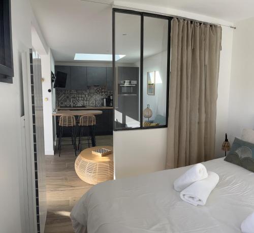拉蒂尔巴勒Lodge LE CABANON accès direct plage !的一间带白色床的卧室和一间厨房