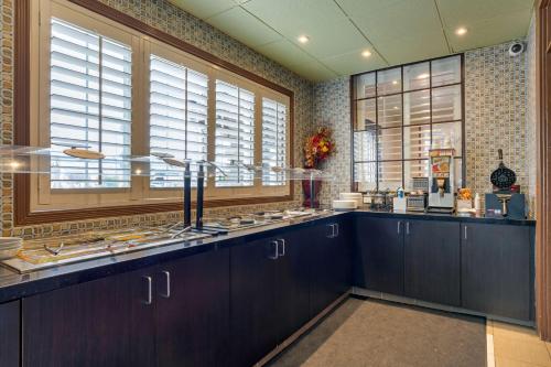 米尔皮塔斯溪涧酒店的厨房配有深色木质橱柜和窗户。