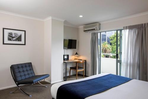 奥克兰奎斯特奥克兰服务式公寓的酒店的客房 - 带一张床、椅子和窗户