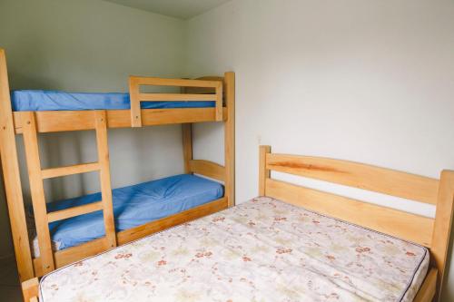 帕罗卡Morada do Mar Aberto - 100 metros da praia的一间卧室配有两张双层床,铺有蓝色床单。