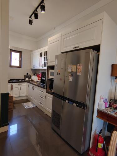 春川The Castle Stay的厨房配有不锈钢冰箱和白色橱柜