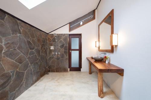 美娜多默克斯潜水度假村的一间带水槽和石墙的浴室