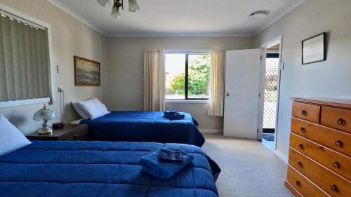 陶波Almost Country的一间卧室设有两张蓝色的床和窗户
