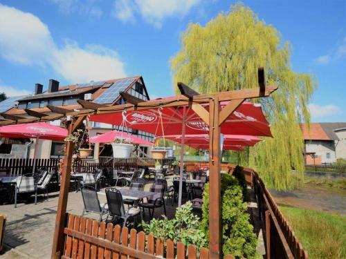 巴特索登-萨尔明斯特Landgasthof Zum Jossatal的一间带桌椅和遮阳伞的餐厅