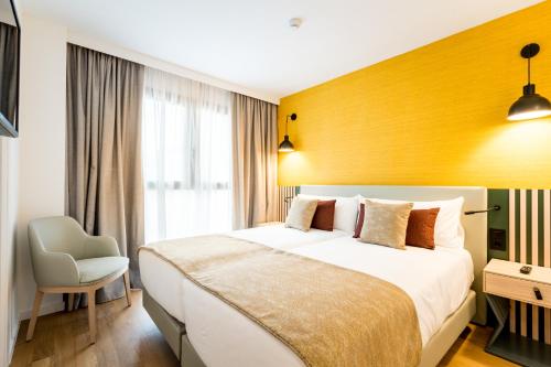 塞维利亚atLumbreras16的一间卧室设有一张大床和黄色的墙壁